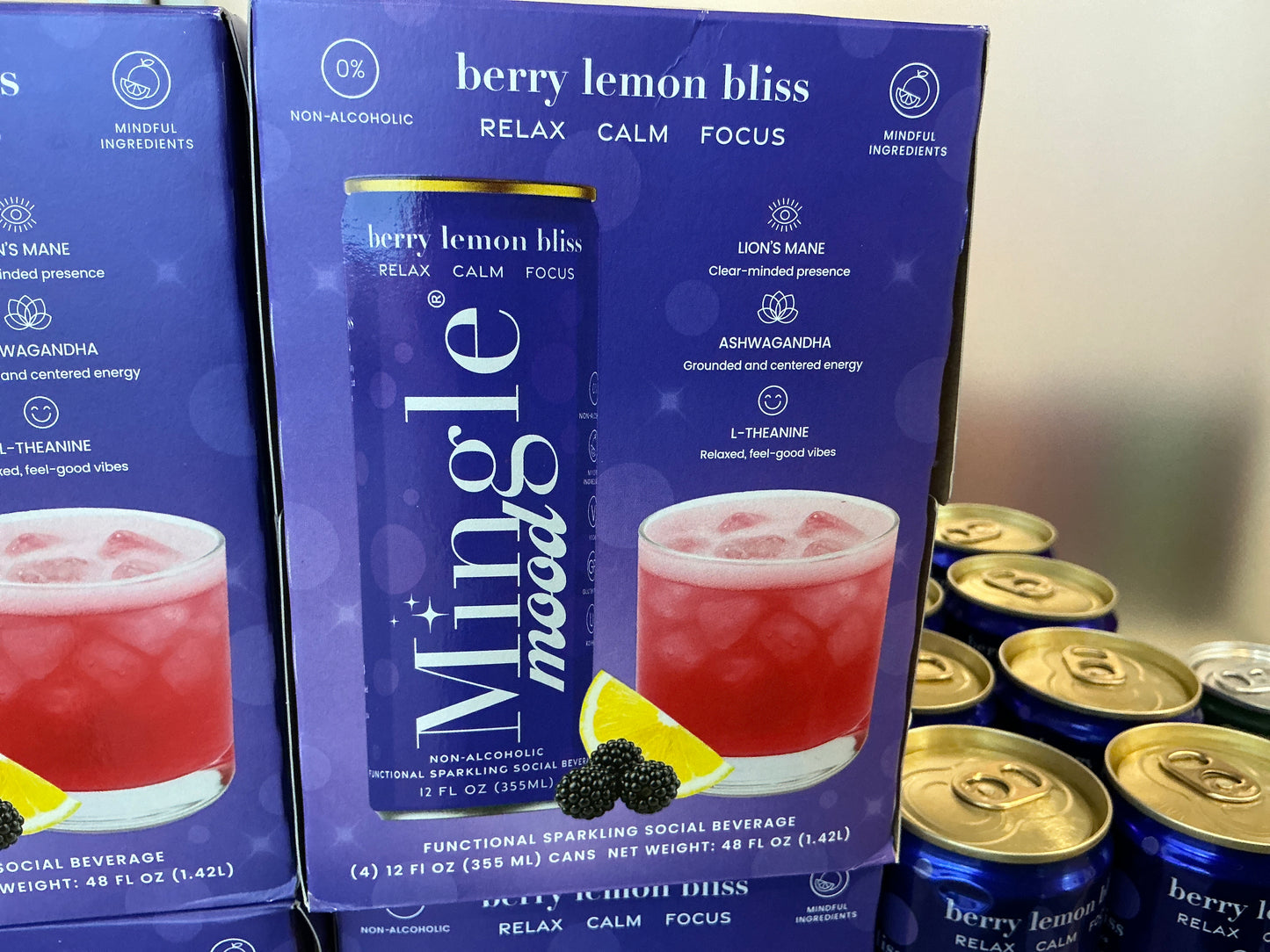 Mingle berry lemon bliss non-alcoholic beverage packaging with cans in the background