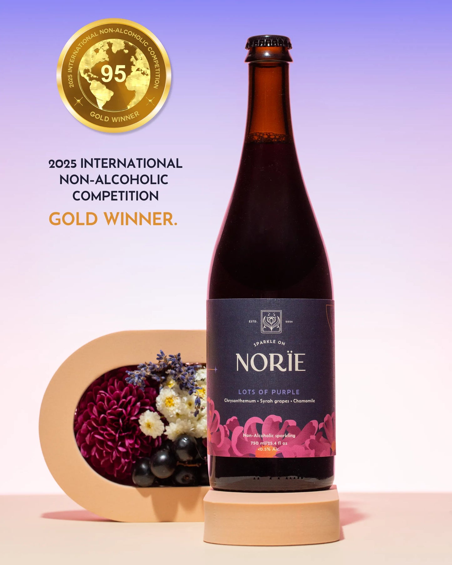 Bottle of Norie non-alcoholic wine with a decorative stand and flowers on a light purple background