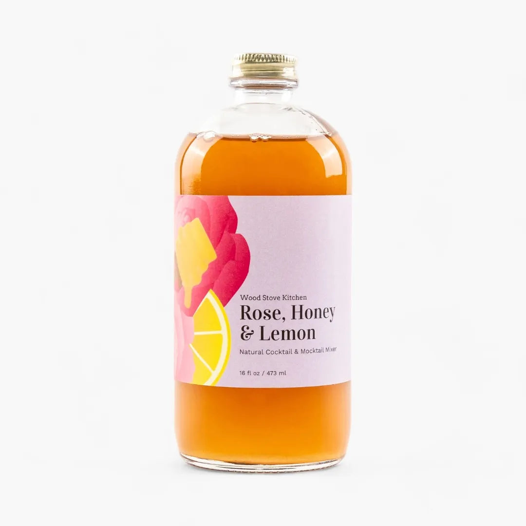 Bottle of 'Rose, Honey & Lemon' cocktail mixer with a colorful label on a white background
