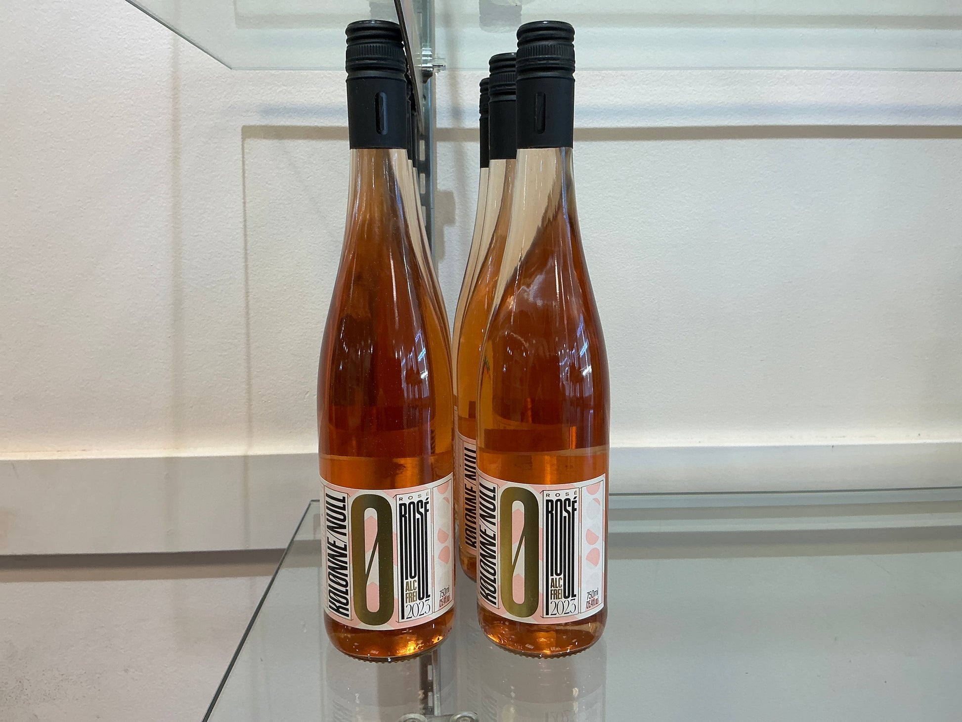 Two bottles of wine with a visible label on a reflective surface.