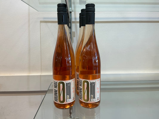 Two bottles of wine with a visible label on a reflective surface.