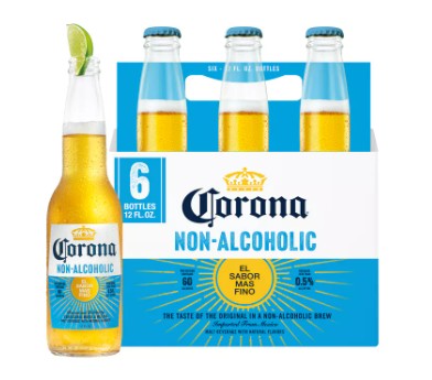 A six-pack of Corona Non-Alcoholic beer bottles with one bottle in front, shown on a white background with a green lime wedge.