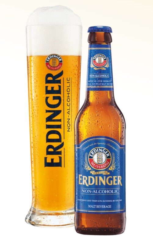 A bottle and a tall glass of Erdinger Non-Alcoholic malt beverage on a plain white background. The glass is filled with golden beer and shows the brand name vertically in black, while the bottle has a blue label and brown glass.