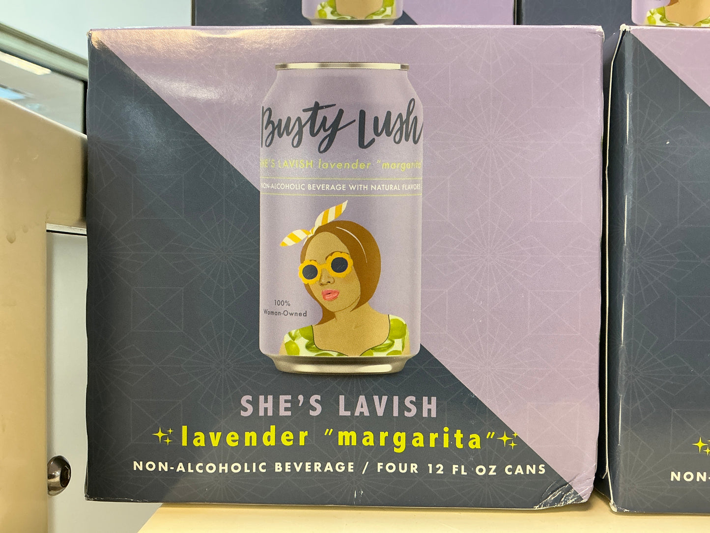 She's Lavish non-alcoholic beverage can packaging on a shelf