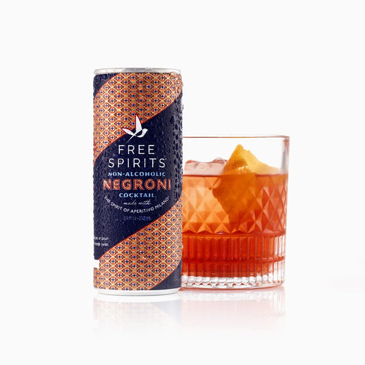 Free Spirits non-alcoholic Negroni cocktail can next to a glass of the cocktail on a white background