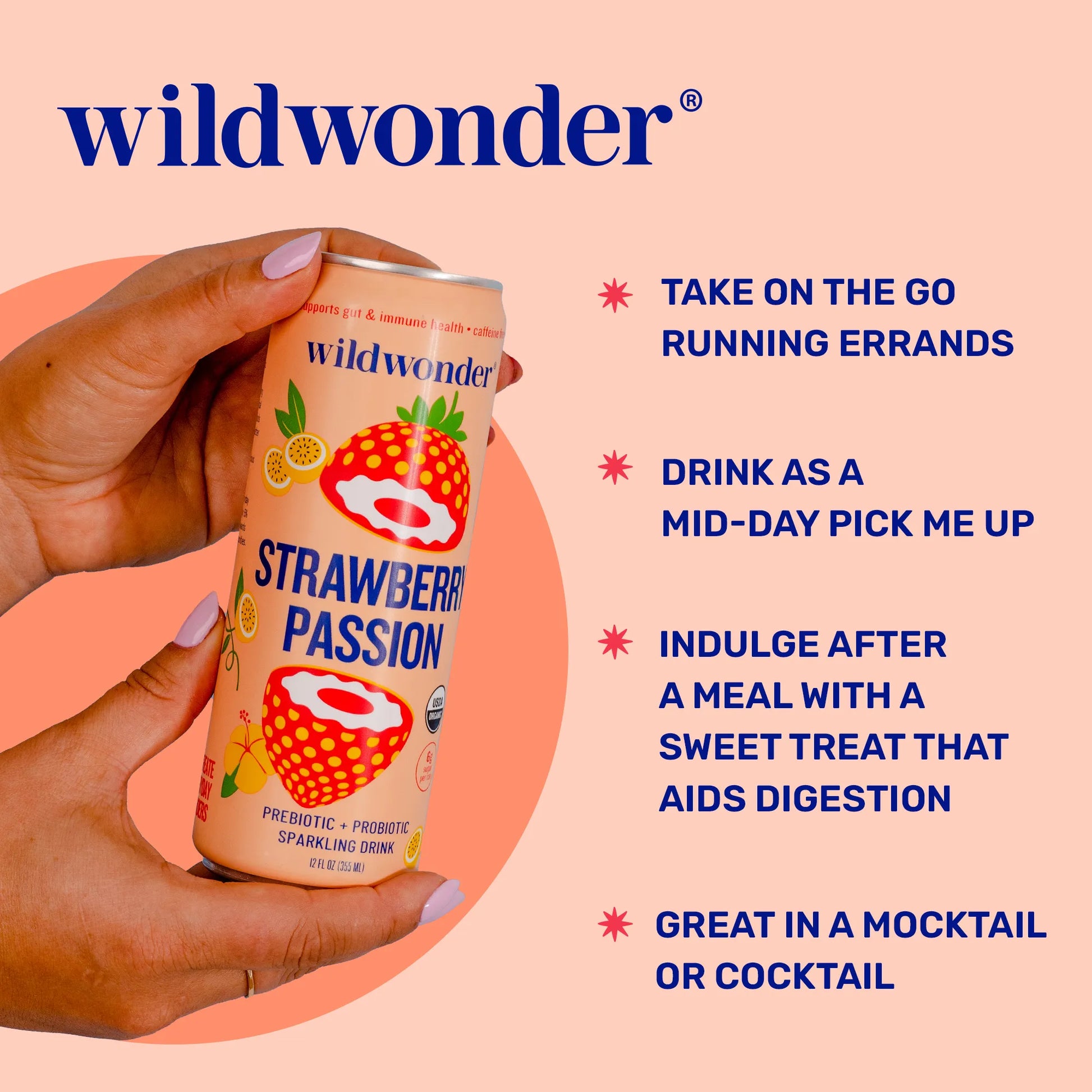 Hand holding a can of wildwonder Strawberry Passion drink with promotional text on a pink background