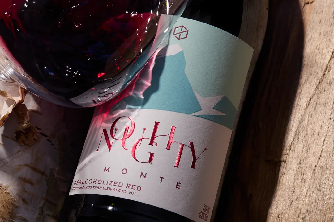 Bottle of 'Noughty Monte' dealcoholized red wine with a label featuring abstract designs.
