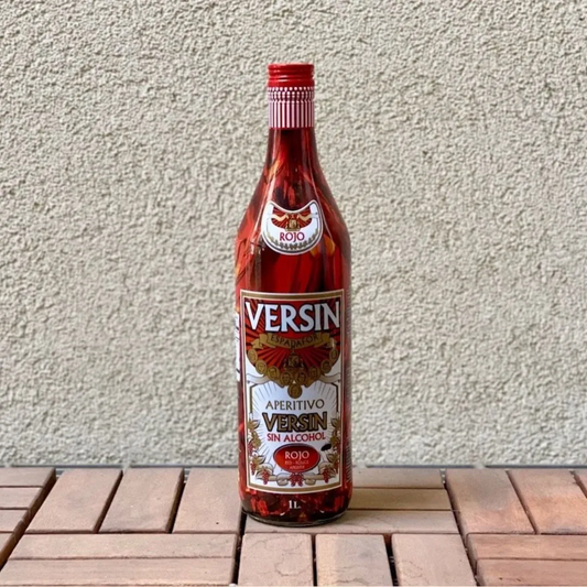 Bottle of Versin Aperitivo on a wooden surface with a light gray background