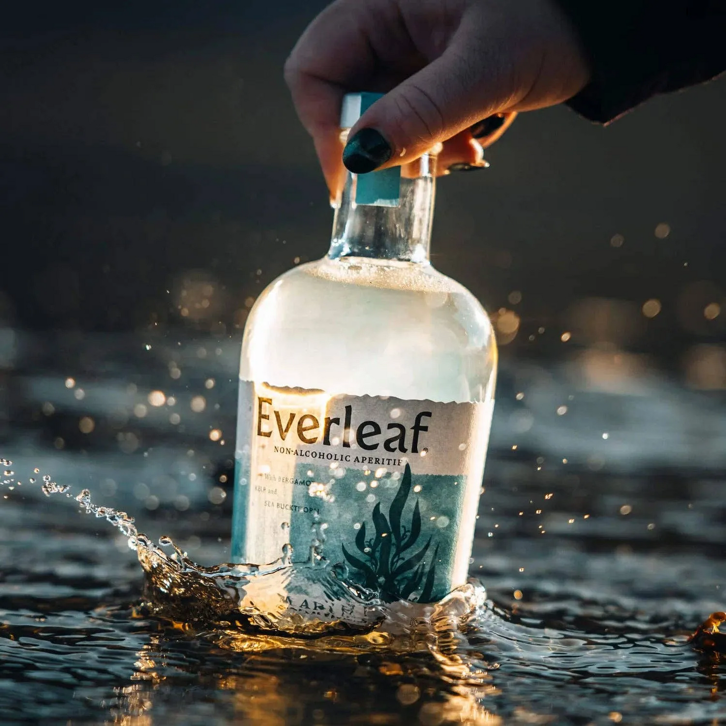 Bottle of Everleaf non-alcoholic appletini being submerged in water