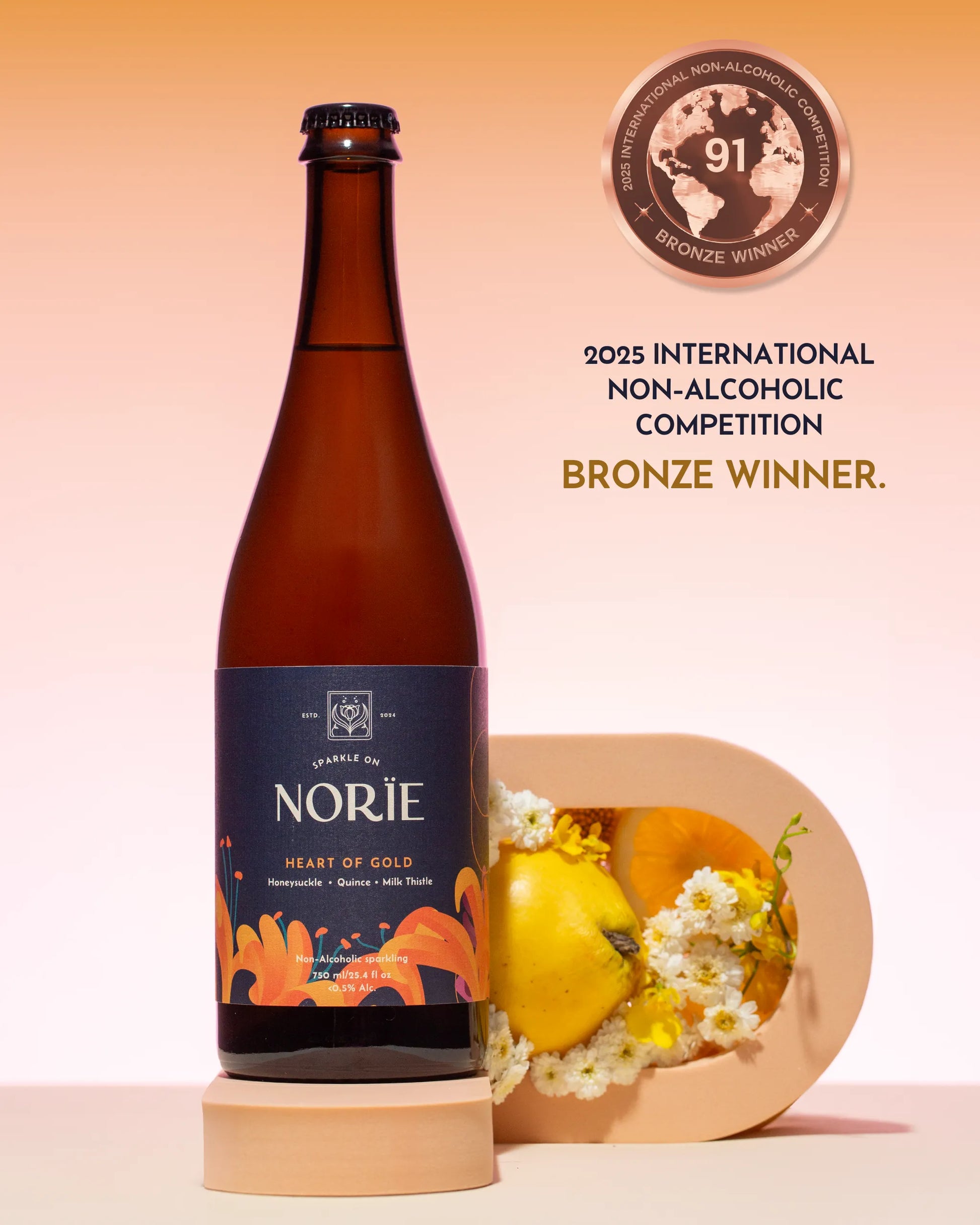 Bottle of Norie 'Heart of Gold' non-alcoholic beer with a decorative plate and flowers on a peach background.