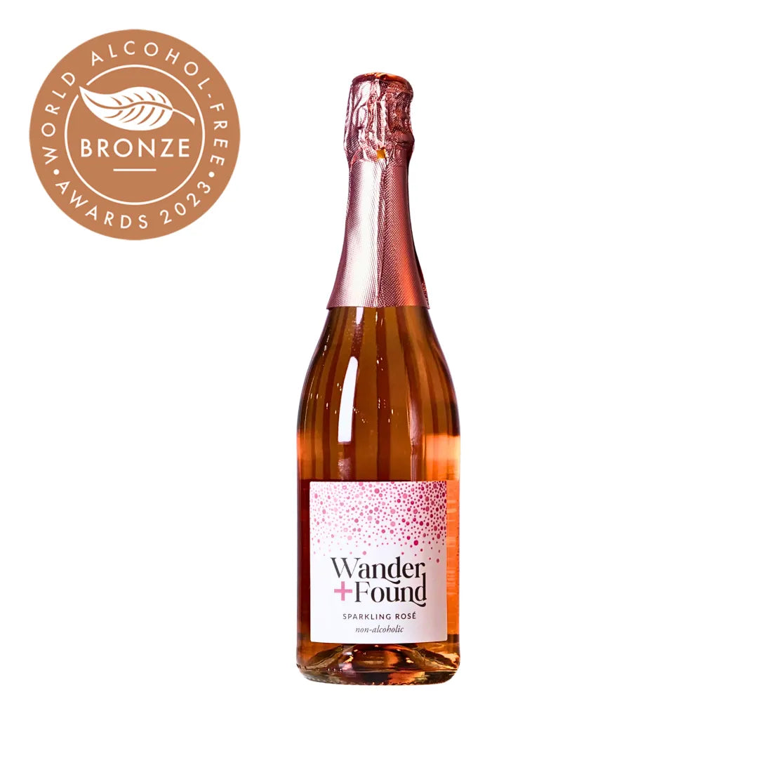 Bottle of Wander + Found sparkling rose wine with a bronze medal from World Alcohol Awards 2023 on a white background.