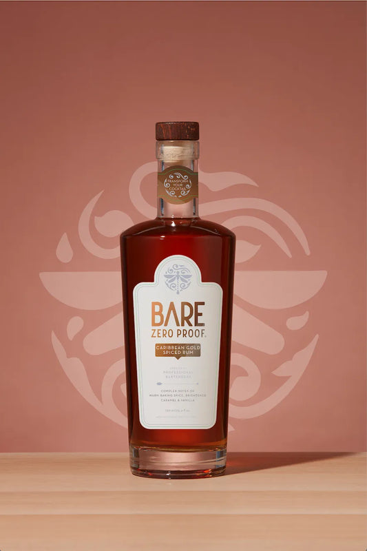 Bottle of Bare Zero Proof on a wooden surface with a pinkish-brown background