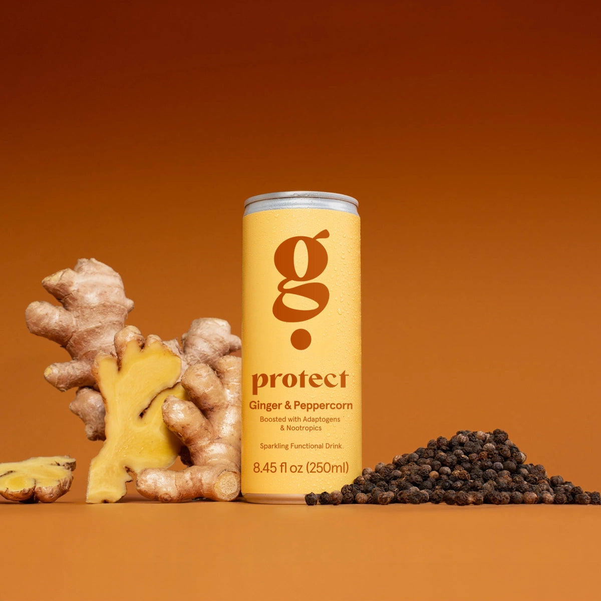 Ginger and peppercorn drink can with ginger root and peppercorns on an orange background