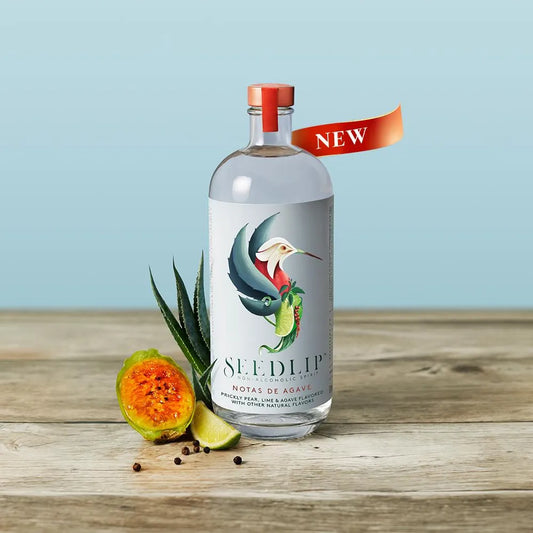 Bottle of Seedlip on a wooden surface with a light blue background