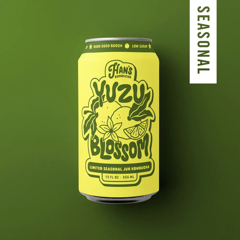 Yellow can of Hans Kombucha Yuzu Blossom on a green background