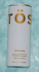 TOS sparkling white tea can on a light blue background