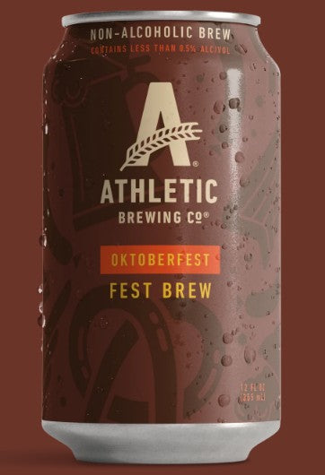 A 12 fl oz can of Athletic Brewing Co. Oktoberfest Fest Brew, featuring a dark brown can with condensation droplets, a large gold 'A' logo, and an orange label accent, set against a solid dark brown background.