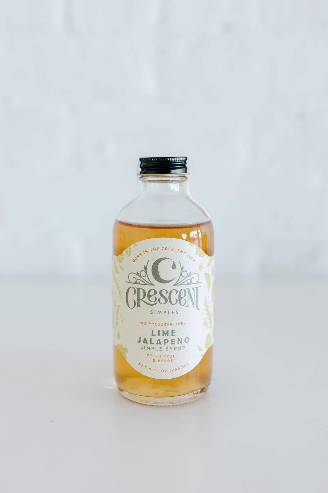 Bottle of Crescent lime simple syrup on a white background